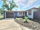 The charming single-story home boasts a well-manicured lawn, landscaping, and a spacious driveway leading to the garage at 905 W 11Th Ave, Mount Dora, FL 32757
