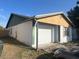 View of attached one car garage of single story home with white door and stucco siding, surrounded by lawn at 930 Buttercup Dr, Lakeland, FL 33801