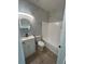 Modern bathroom with tub, white vanity, and neutral marble look tile at 352 Madina Cir, Davenport, FL 33837
