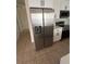 Stainless steel refrigerator complements the modern kitchen with white cabinets and granite countertops at 352 Madina Cir, Davenport, FL 33837