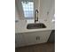 Modern kitchen island with stainless steel sink, black faucet, white cabinets and granite countertop at 352 Madina Cir, Davenport, FL 33837