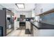 Modern kitchen with stainless steel appliances, gray backsplash, and white cabinets at 1007 Maya Ave, Orlando, FL 32822