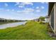 Lush backyard with a serene water view, complemented by the home's screened lanai at 1014 Umbria Dr, Kissimmee, FL 34759
