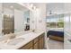 Bright bathroom featuring a double sink vanity, modern fixtures, and a view into the main bedroom with tranquil lake views at 1014 Umbria Dr, Kissimmee, FL 34759