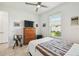 Cozy bedroom with ceiling fan, large window, and dresser with television at 1014 Umbria Dr, Kissimmee, FL 34759