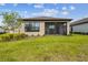 Backyard view of a well-maintained home featuring a screened lanai and manicured lawn at 1014 Umbria Dr, Kissimmee, FL 34759