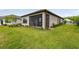 Backyard view featuring a home with a screened lanai and manicured lawn at 1014 Umbria Dr, Kissimmee, FL 34759