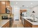 Stylish kitchen featuring stainless steel appliances, a breakfast bar, and an abundance of natural light at 1014 Umbria Dr, Kissimmee, FL 34759