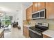 Kitchen shows stainless steel appliances, wooden cabinets and breakfast bar overlooking the great room with water views at 1014 Umbria Dr, Kissimmee, FL 34759