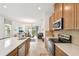 Open kitchen featuring stainless steel appliances, wooden cabinets and adjacent living spaces for easy entertaining at 1014 Umbria Dr, Kissimmee, FL 34759