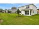 Expansive backyard with pristine lawn, complemented by covered patio and neighborhood views at 1019 Cloud Ridge Ct, Mount Dora, FL 32757