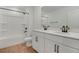 Modern bathroom with double sink vanity, white cabinets, and a tub with shower at 1019 Cloud Ridge Ct, Mount Dora, FL 32757