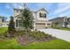 Two-story home featuring a three-car garage, stone accents, and freshly installed landscaping at 1019 Cloud Ridge Ct, Mount Dora, FL 32757