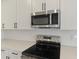 Close up of stainless steel microwave and range with white subway tile backsplash at 1019 Cloud Ridge Ct, Mount Dora, FL 32757