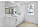 Bright bathroom features double sinks, granite countertops, and a view to the outdoors at 1067 Cloud Ridge Ct, Mount Dora, FL 32757