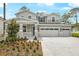 Charming two-story home with a three car garage, stone accents, and professionally landscaped front yard at 1067 Cloud Ridge Ct, Mount Dora, FL 32757