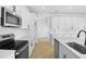 Bright kitchen featuring white cabinets, stainless appliances, a large center island, and wood-look tile floor at 1067 Cloud Ridge Ct, Mount Dora, FL 32757
