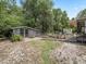 View of backyard shed with double french doors, red brick walkway, and lush landscaping at 1081 Se 174Th Ter, Silver Springs, FL 34488