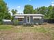 Charming single-story home featuring a metal roof, fenced yard and well-lit entrance, set against a lush green backdrop at 1081 Se 174Th Ter, Silver Springs, FL 34488
