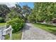 Long driveway with brick pavers lined with mature trees and manicured landscaping at 1104 E Anderson St, Orlando, FL 32801