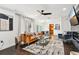 Open-concept living room with sleek furniture, ceiling fan, and view into the dining room at 1104 E Anderson St, Orlando, FL 32801
