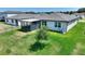 Aerial view of a well-maintained backyard with a screened patio, lush lawn, and young trees at 1158 Oak Valley Dr, Auburndale, FL 33823