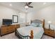 The bedroom features a black metal frame bed with blue pillows, wood furniture, a ceiling fan and a TV at 1158 Oak Valley Dr, Auburndale, FL 33823