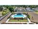 Elevated aerial perspective of a luxurious community pool, cabana, manicured grounds, and pool furniture at 1158 Oak Valley Dr, Auburndale, FL 33823