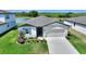 Charming single-Gathering home featuring a two-car garage, a well-manicured lawn, and fresh landscaping at 1158 Oak Valley Dr, Auburndale, FL 33823