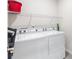 Laundry room with a washer, dryer, white wire shelf, and room for storage at 1158 Oak Valley Dr, Auburndale, FL 33823