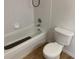 Simple bathroom featuring a clean white bathtub, white tile surround and matching toilet at 13226 Galicia St # 103, Orlando, FL 32824