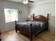 Bright bedroom with wood laminate flooring, lots of natural light, and a classic wooden bed frame at 13226 Galicia St # 103, Orlando, FL 32824