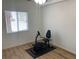 Bedroom with hardwood floors, ceiling fan, and a Bowflex exercise bike with rubber mat at 13226 Galicia St # 103, Orlando, FL 32824