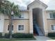 Inviting two-story exterior featuring a well-maintained lawn, blue accents and a prominent palm tree at 13226 Galicia St # 103, Orlando, FL 32824