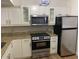 Efficient kitchen featuring white cabinets, stainless steel appliances and ample counter space at 13226 Galicia St # 103, Orlando, FL 32824