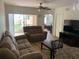 Comfortable living room featuring a brown sofa set, wood flooring and access to an outdoor patio at 13226 Galicia St # 103, Orlando, FL 32824