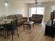 Open-concept living room with laminate flooring and a comfortable sofa set near the dining area at 13226 Galicia St # 103, Orlando, FL 32824