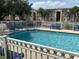 Inviting community pool with blue lounge chairs and well-maintained fencing, perfect for relaxation at 13226 Galicia St # 103, Orlando, FL 32824