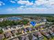 Aerial view of a residential neighborhood featuring a lake, community amenities, and neatly arranged homes at 1416 Lexington Ave, Davenport, FL 33837