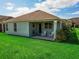Lush backyard with a covered patio featuring comfortable seating, perfect for outdoor relaxation and entertaining at 1416 Lexington Ave, Davenport, FL 33837