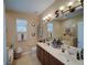 Bathroom featuring a double sink vanity with a large mirror and abundant counter space and storage at 1416 Lexington Ave, Davenport, FL 33837