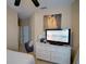 Bright bedroom with white dresser, TV, and decoratively adorned with an art piece above the dresser at 1416 Lexington Ave, Davenport, FL 33837