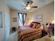 Cozy bedroom features a comfortable bed with patterned linens, a ceiling fan and a decorative window at 1416 Lexington Ave, Davenport, FL 33837