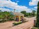 Inviting community entrance with brick-paved roads, lush greenery, and an elegant guardhouse at 1416 Lexington Ave, Davenport, FL 33837