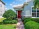 Inviting front entrance with a brick pathway leading to a red door surrounded by well-maintained landscaping at 1416 Lexington Ave, Davenport, FL 33837