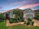 Charming home with landscaped front yard, brick walkway, and inviting red front door at 1416 Lexington Ave, Davenport, FL 33837