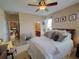 Comfortable main bedroom with decorative pillows and furnishings, ceiling fan, and adjacent bathroom and kitchen at 1416 Lexington Ave, Davenport, FL 33837