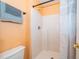 Bathroom showcasing a shower with white tile walls, orange walls, and light orange walls at 153 Pine Isle Dr, Sanford, FL 32773