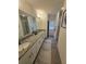 Bathroom featuring double vanity with granite countertops, framed mirrors, and tiled floors at 16043 Scarpetta St, Winter Garden, FL 34787