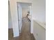 A carpeted hallway leads to a bedroom filled with natural light, showcasing a calm and inviting space at 16043 Scarpetta St, Winter Garden, FL 34787